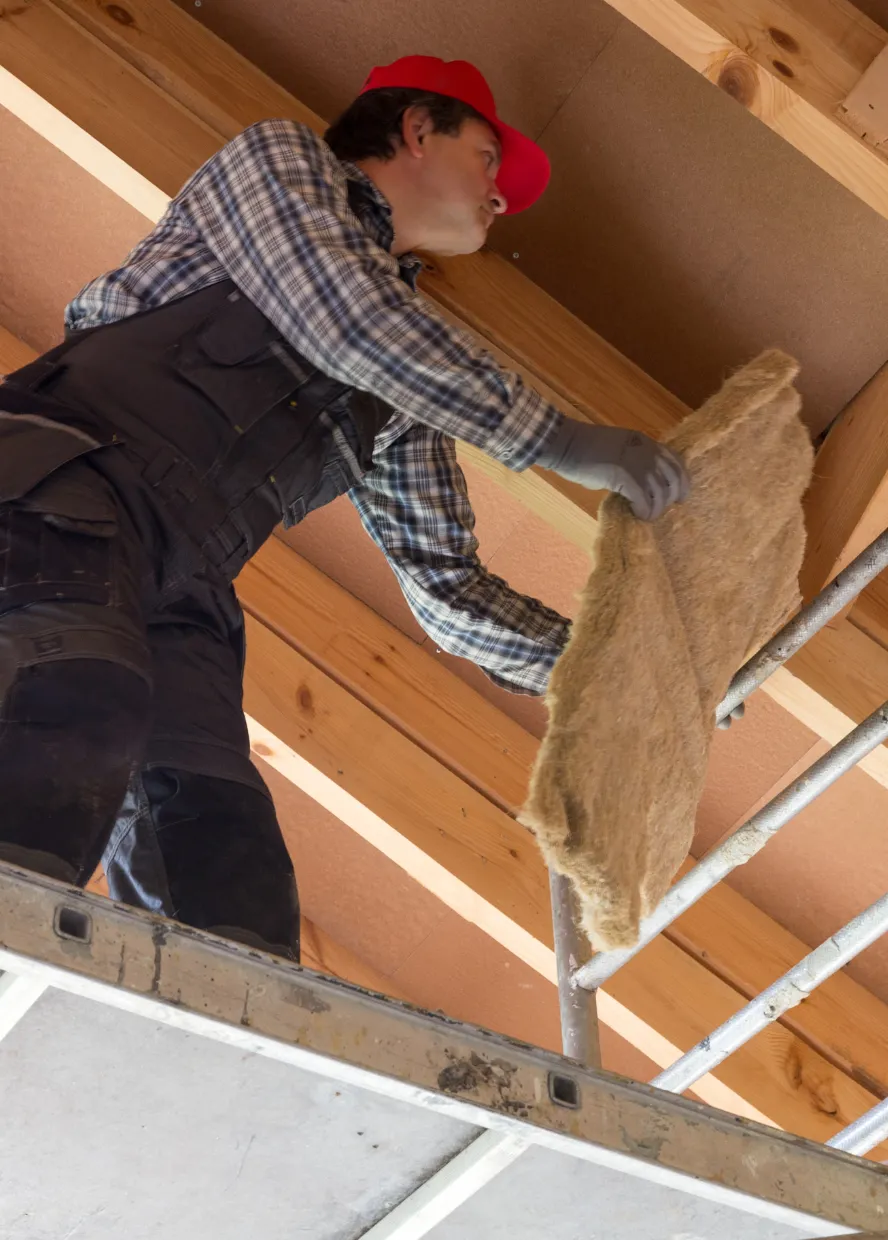 Home Wow Pro construction worker installing insulation between wood framing for residential building and remodeling projects in Los Angeles