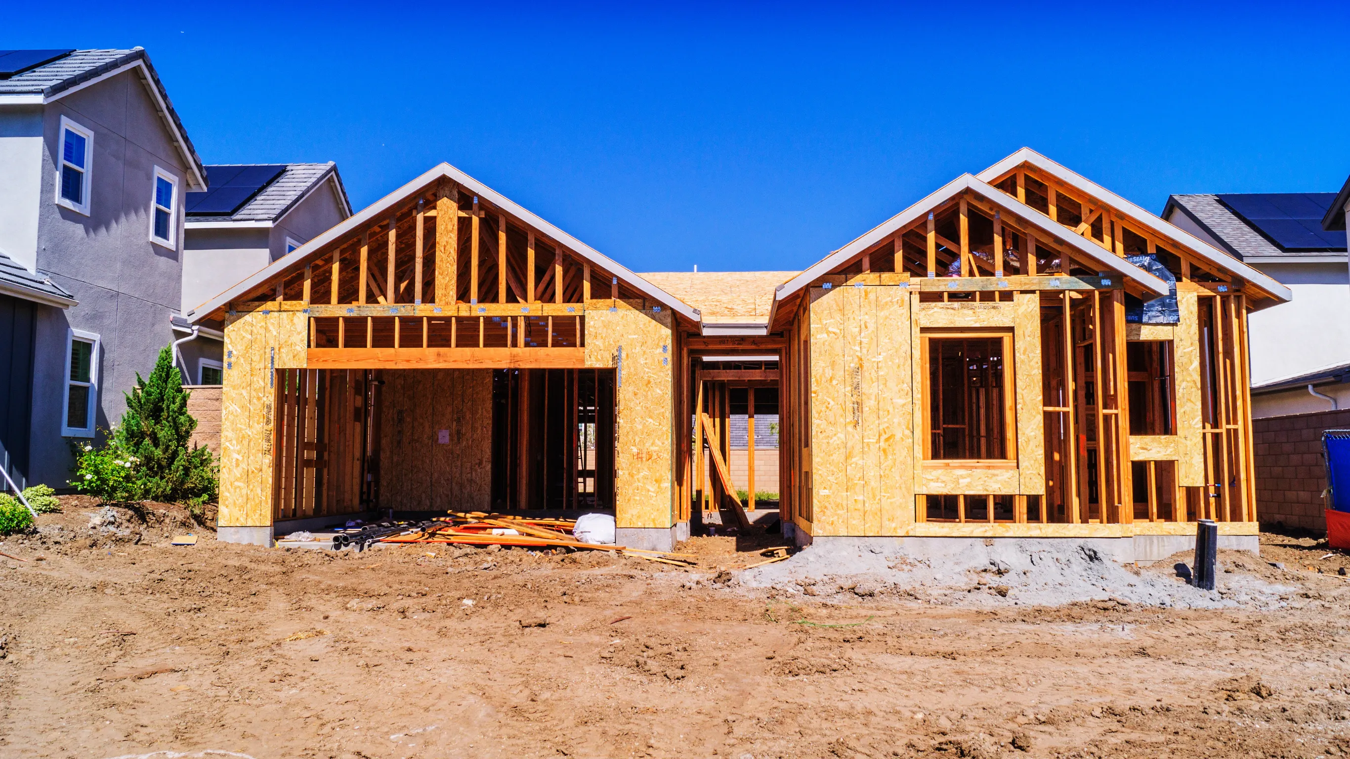 Before new home construction project in Los Angeles showing a residential house in wood framing stage with exposed sheathing and unfinished exterior