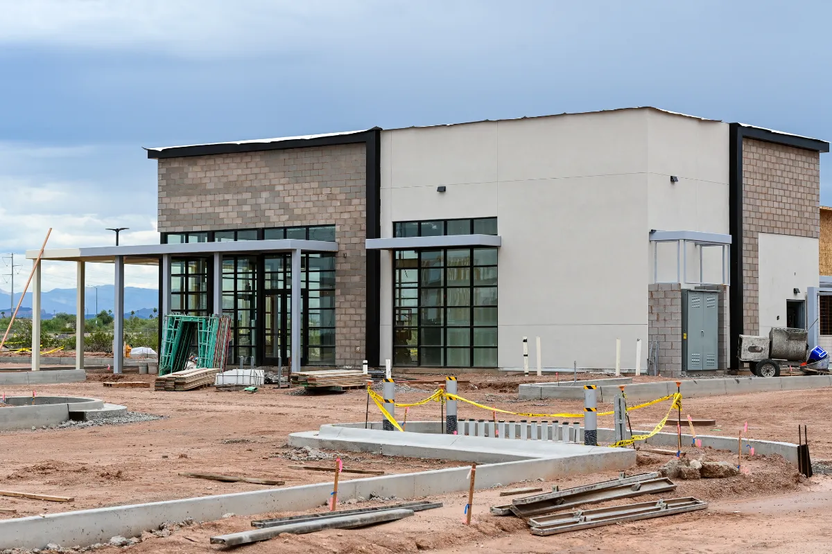 Modern commercial building construction in Los Angeles with storefront glass, concrete work, and active job site preparation