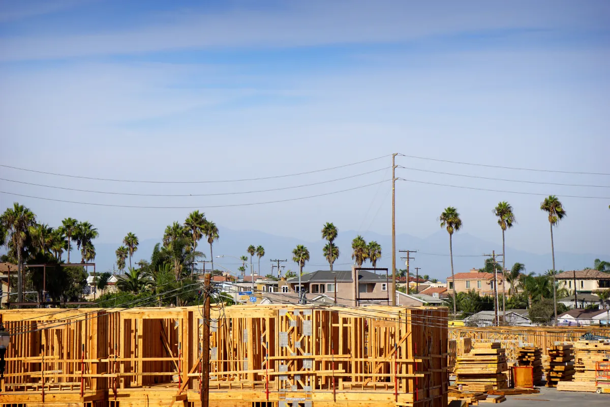 New home construction in Los Angeles with wood framing, building materials, and residential houses in the background