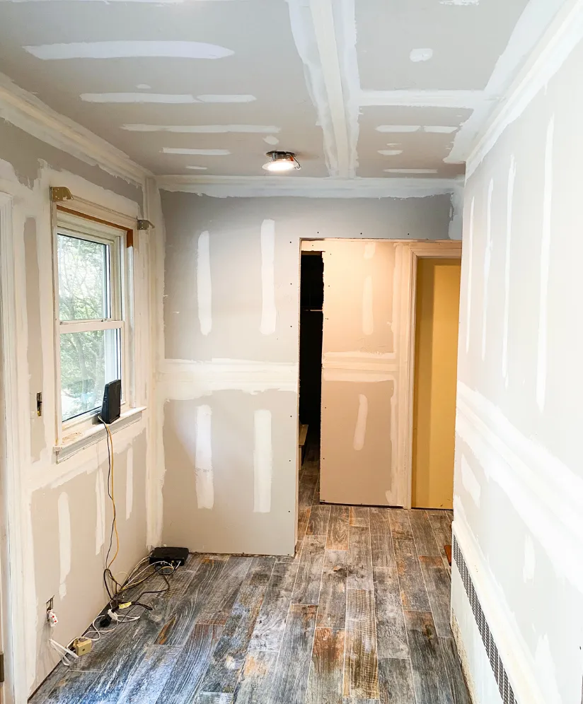 Los Angeles residential remodeling project showing interior drywall finishing, ceiling repairs, window trim, flooring installation, and room renovation work in progress